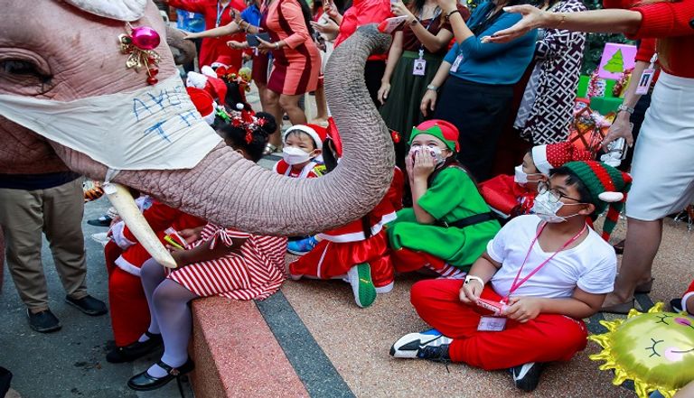 فيلة في زيّ “بابا نويل” توزع الكمامات على تلاميذ تايلاند